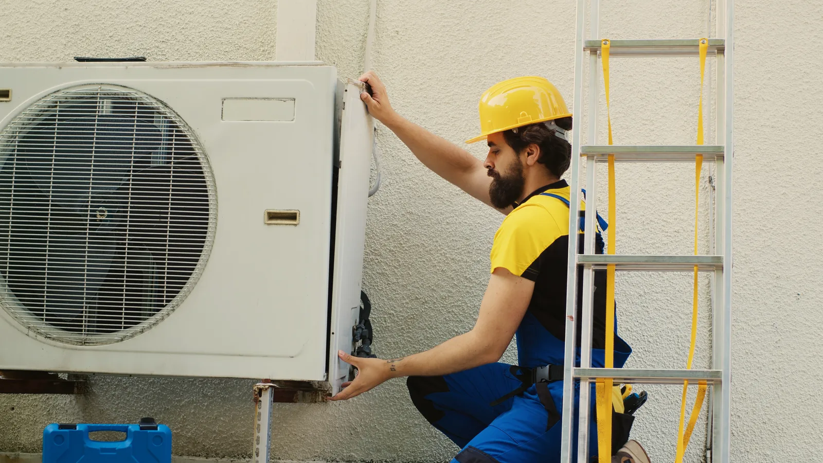 An electrician working on the wiring inside an air conditioning unit